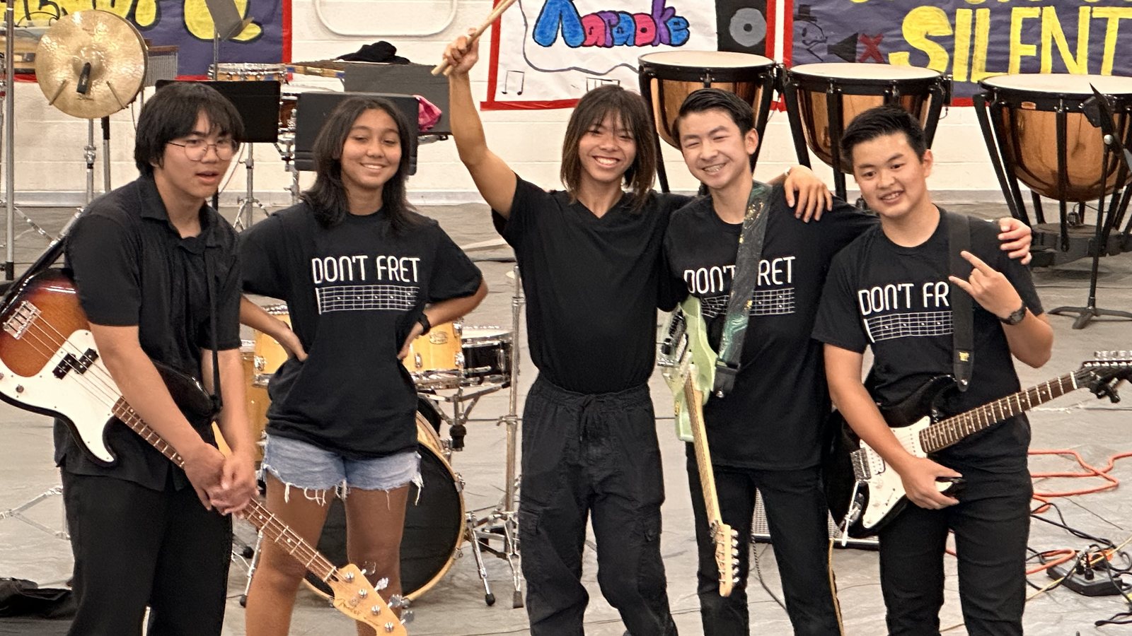 The five band members lined up with guitars and bass after the promotion performance
