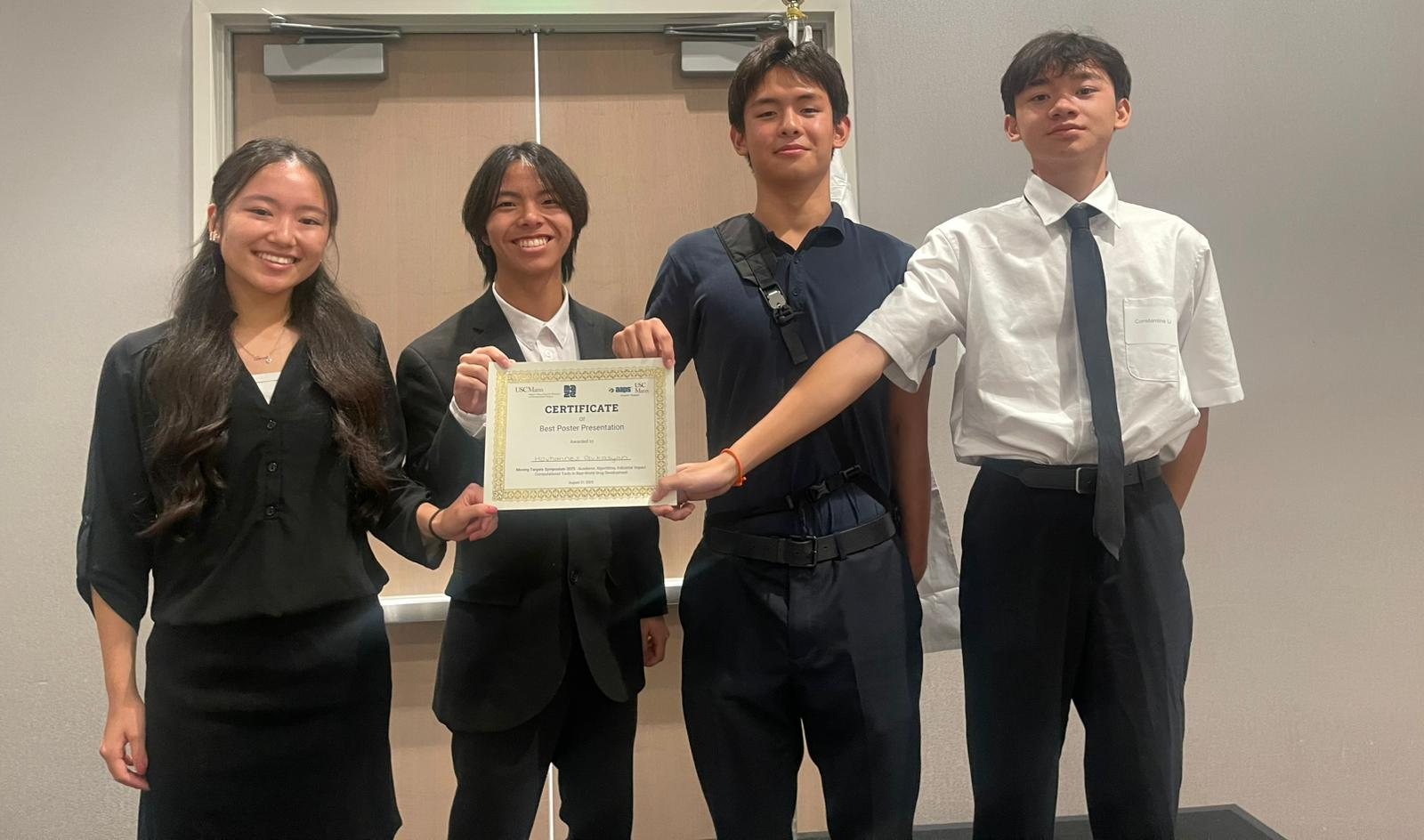 Four students in white shirts and ties holding up the Best Poster certificate